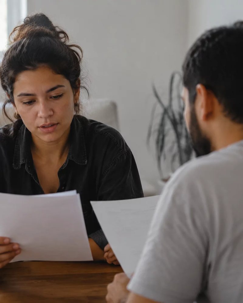 Grupo sentado numa sala clara enquanto uma pessoa defende um ponto de vista